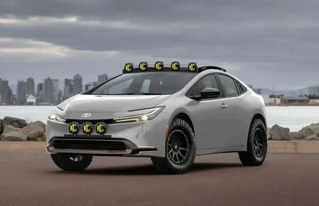 Digital render of a 2023 Toyota Prius with an off-road lift kit, all-terrain tires, and a roof rack concept.